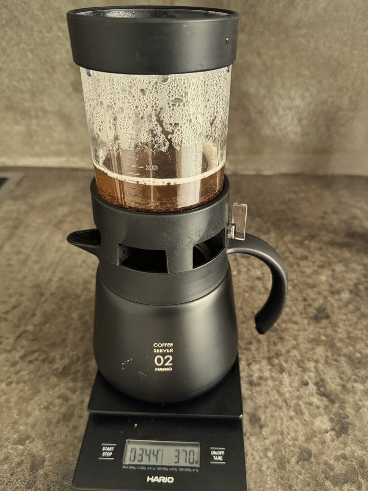 A Hario immersion dripper on a coffee server and scale, the timer at 3:44 and 370 grams.